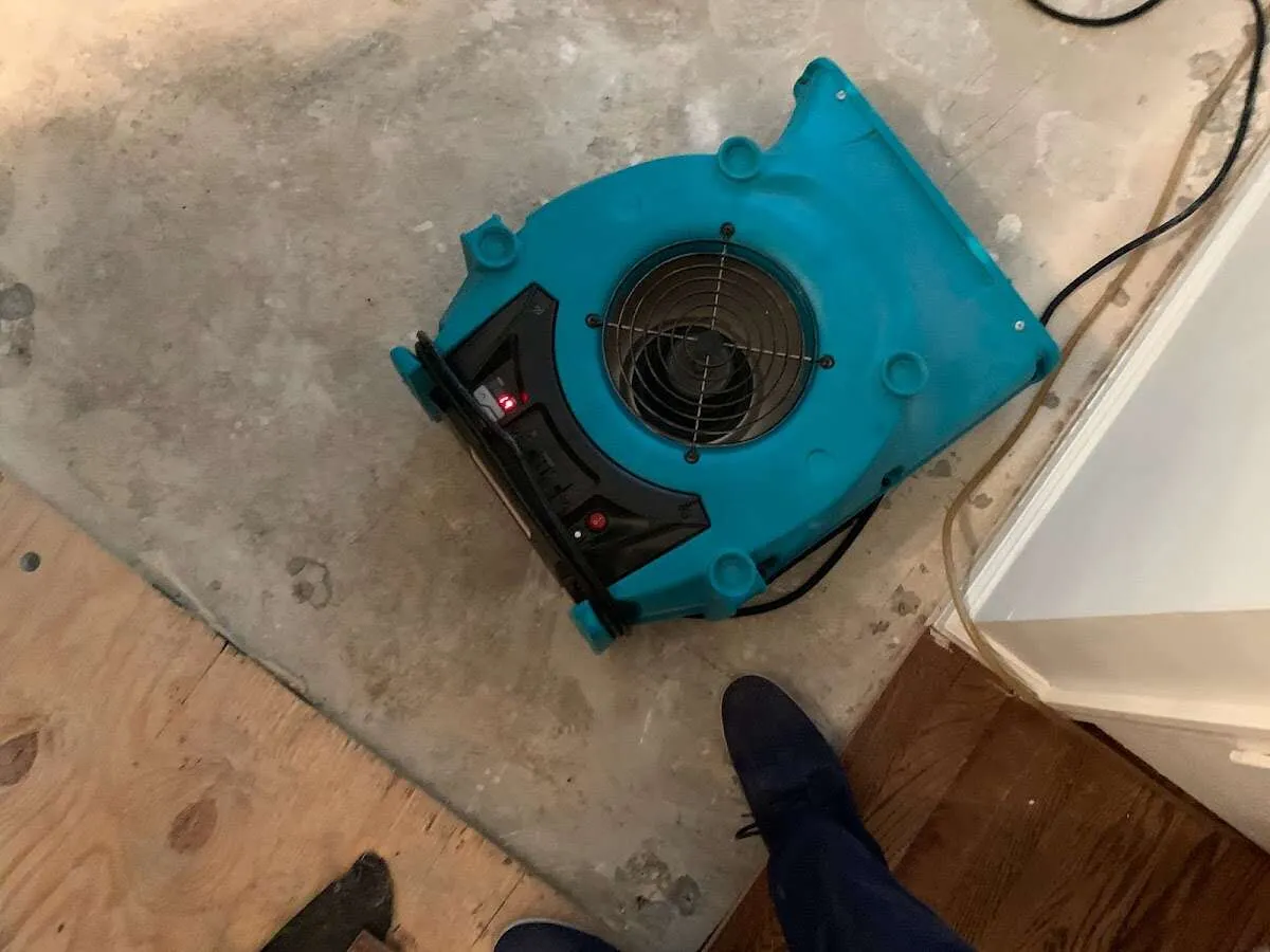 Air mover drying subfloor during Commercial Water Damage Restoration in Ewing